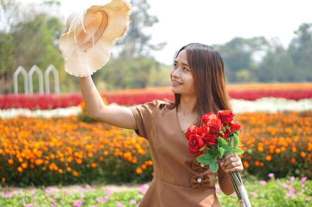 Asian woman smiling happily among beautiful flowers