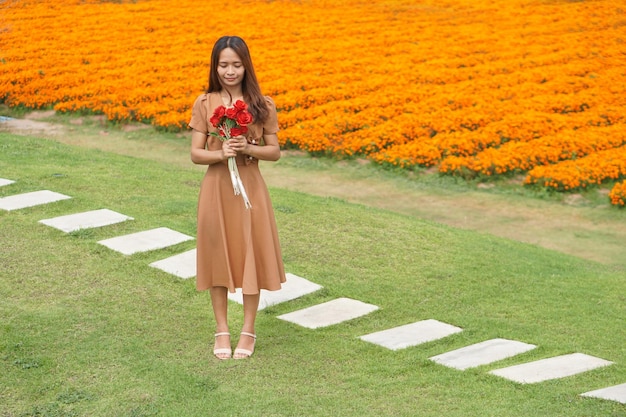 Asian woman smiling happily among beautiful flowers