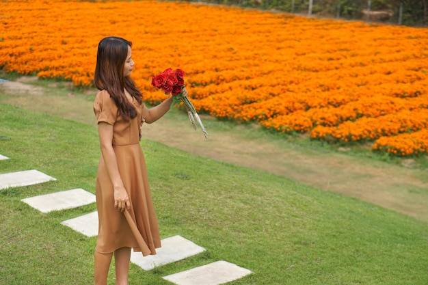 Asian woman smiling happily among beautiful flowers