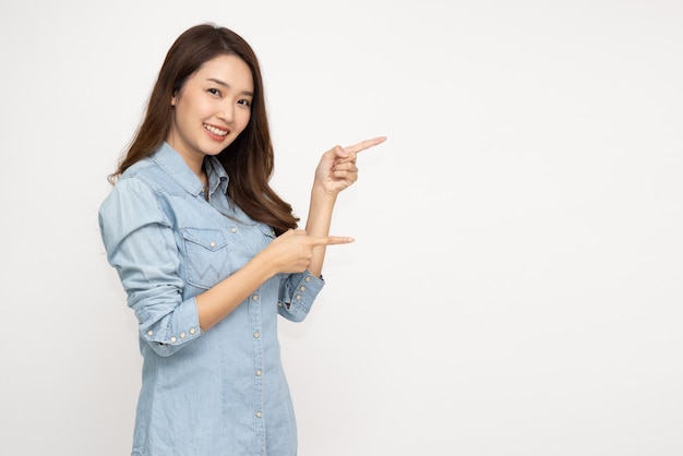 Asian woman smiling  pointing to empty copy space isolated on white background