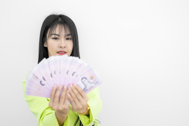 Asian woman smiling while holding Thailand Baht money in hands on white background Asian woman celebrate happiness wealth happy money smiling face Asian woman holding cash notes