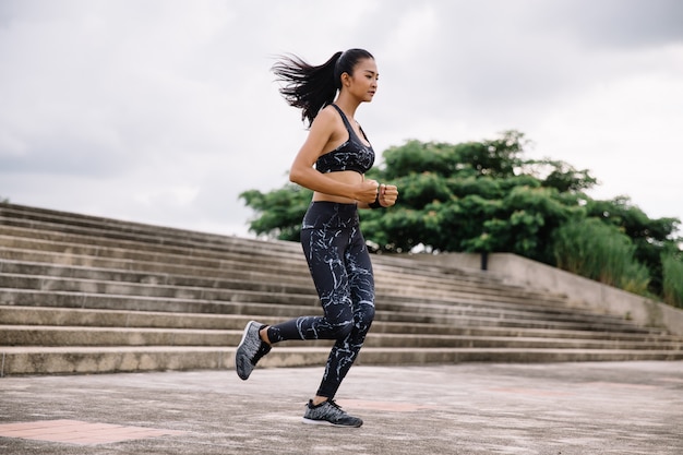 Asian woman sport woman running upstairs on city stairs