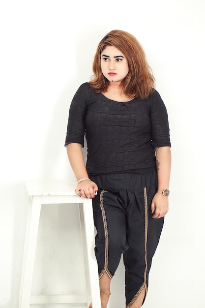 Photo asian woman stands in front of a white stool wearing top and printed cotton dhoti