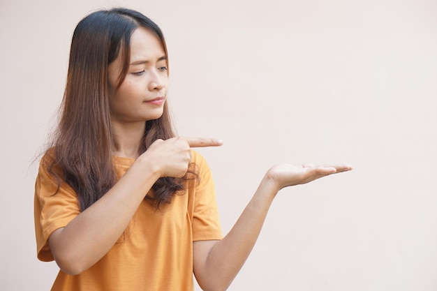 An Asian woman stretches her hand to the side like an empty object on her hand