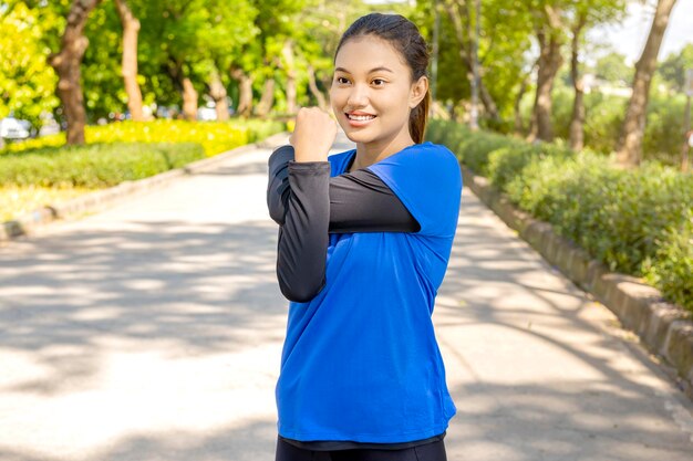 Asian woman stretching her arms before running