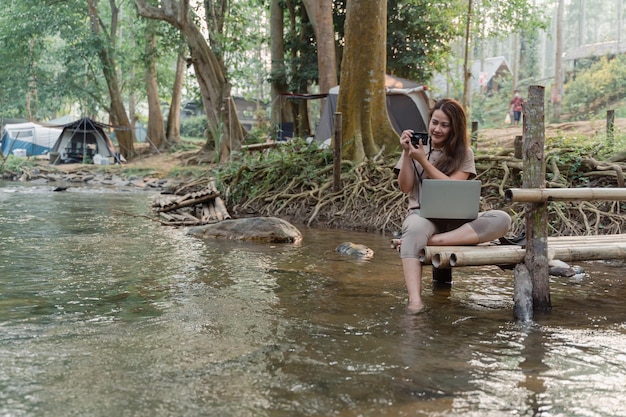 Asian woman travel and camping alone at natural park in Thailand. Recreation and journey outdoor activity lifestyle.