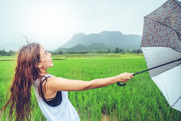 Asian woman travel relax. Women stand in rain umbrellas.