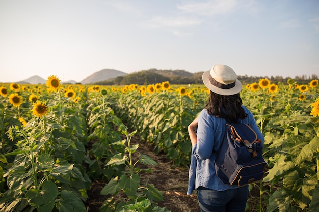 asian woman traveler hand up relax with backpack looking at amazing mountains and forest