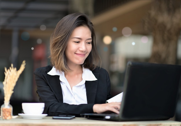 Asian woman use laptop for work in coffee shop