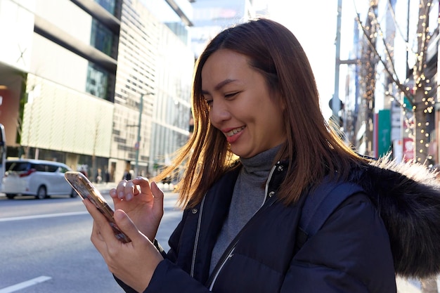 Asian woman using smartphone on the city street