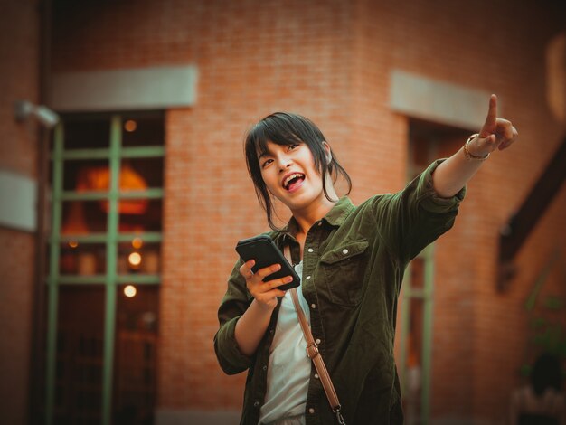 Asian woman using smartphone with happy mood in shopping mall