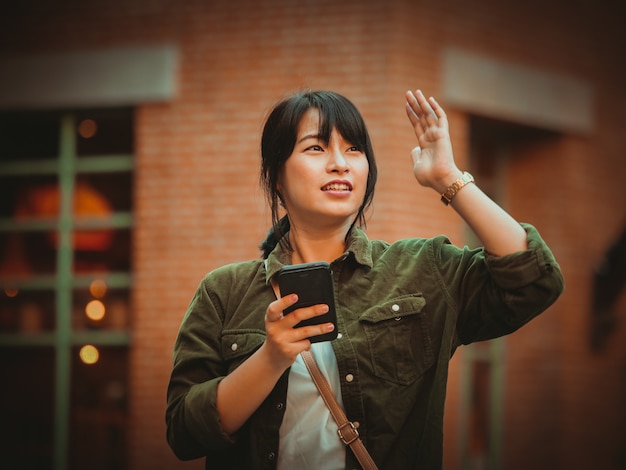 Asian woman using smartphone with happy mood in shopping mall