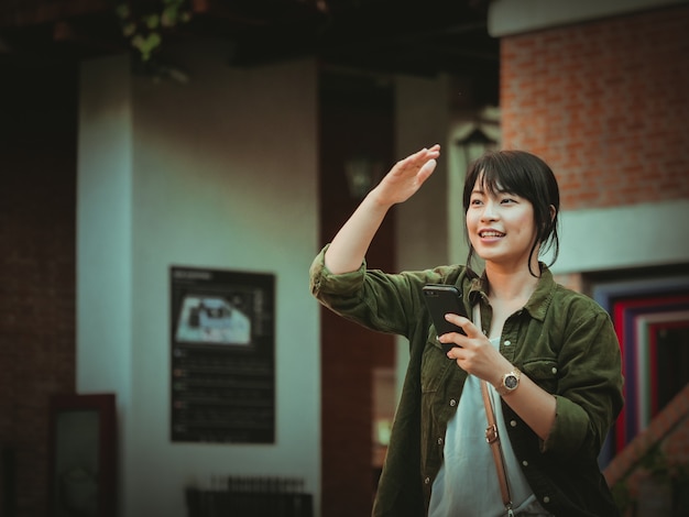 Asian woman using smartphone with happy mood in shopping mall