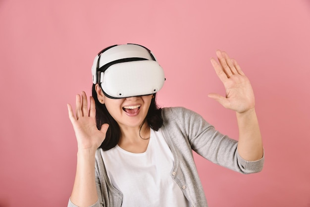 Asian woman using vr glasses Watching movie and playing video games from virtual reality headset Young woman amazing with new experience by vr technology Studio shot