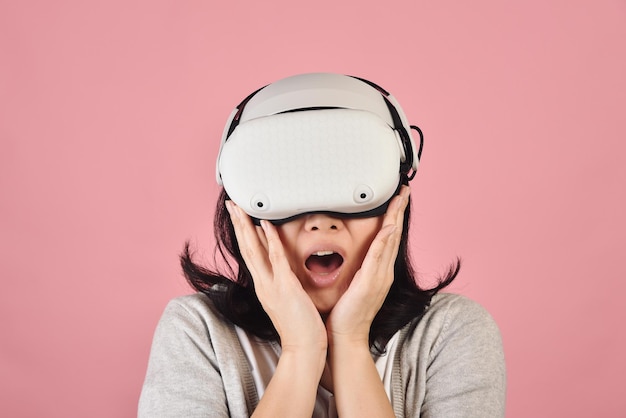 Asian woman using vr glasses Watching movie and playing video games from virtual reality headset Young woman amazing with new experience by vr technology Studio shot