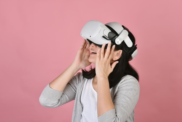 Asian woman using vr glasses Watching movie and playing video games from virtual reality headset Young woman amazing with new experience by vr technology Studio shot