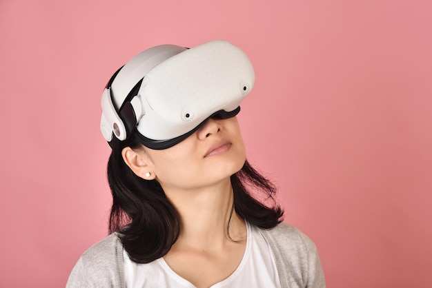 Asian woman using vr glasses Watching movie and playing video games from virtual reality headset Young woman amazing with new experience by vr technology Studio shot