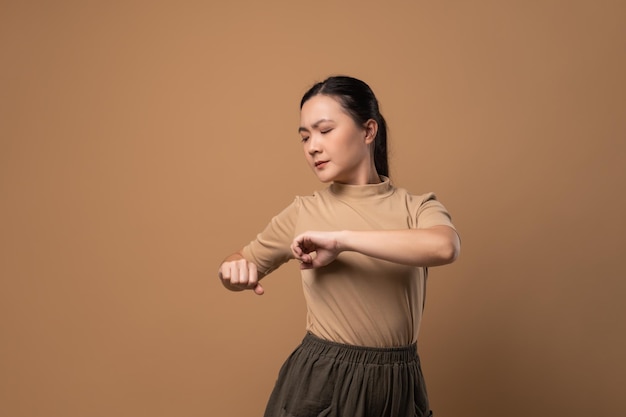 Asian woman was sick with body pain touching her body and standing isolated on beige background