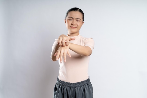 Asian woman was sick with irritate itching her skin standing isolated on white background