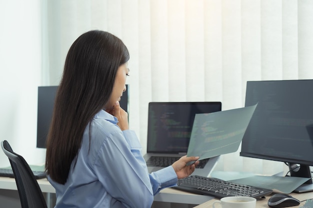 Asian woman was stressed in the early morning while contemplating the programs and codes on the computer screen