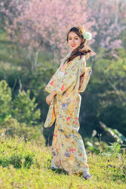 Asian woman wearing japanese traditional kimono at sakura garden.