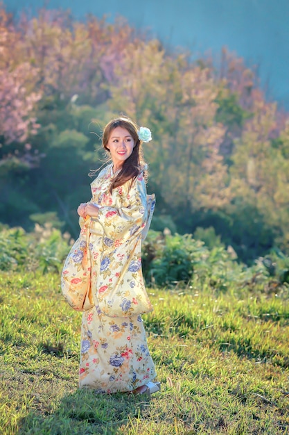 Asian woman wearing japanese traditional kimono at sakura garden.