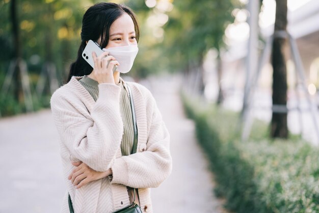 Asian woman wearing a mask while walking on the street