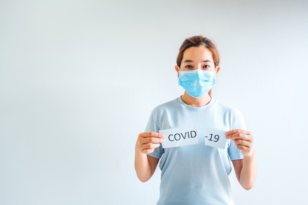 Asian woman wearing medical mask tearing card