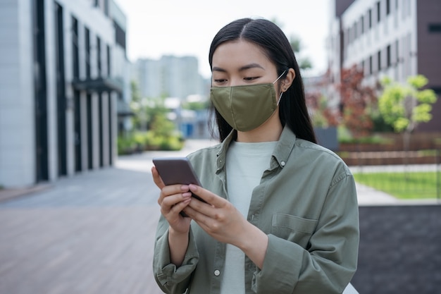 asian woman wearing protection face mask using mobile phone communication online