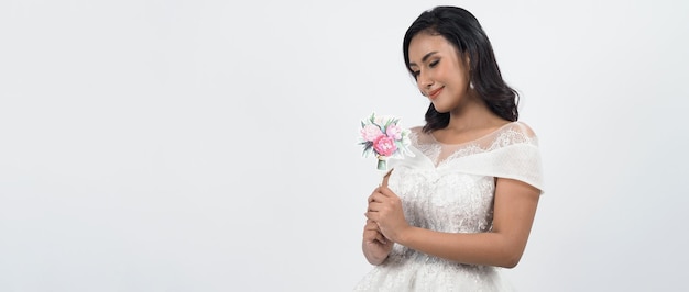 Asian woman in white wedding dress Thai bride poses before the wedding day A young woman is happy in a wedding dress Portrait shot white background in studio Marriage dress for marriage ceremony