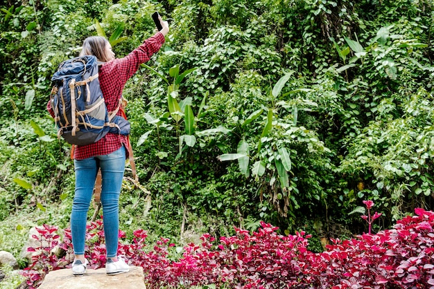 Asian woman with a backpack searching the signal for her mobile phone