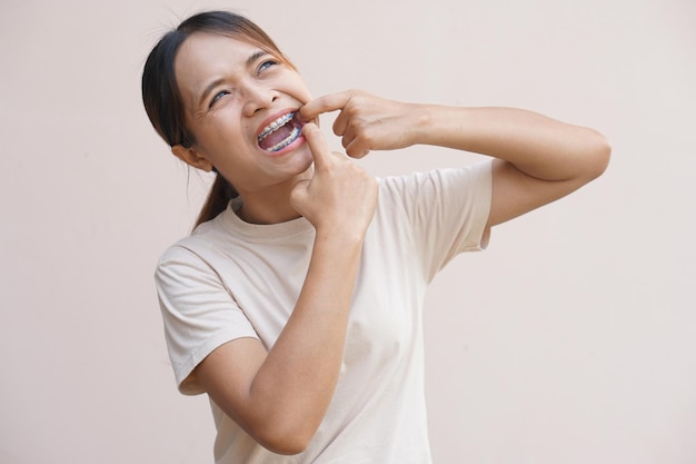 Asian woman with food scraps stuck in her teeth