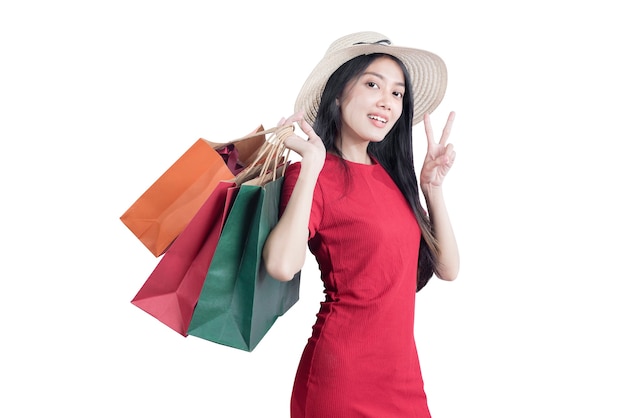 Asian woman with hat carrying shopping bags isolated over white background