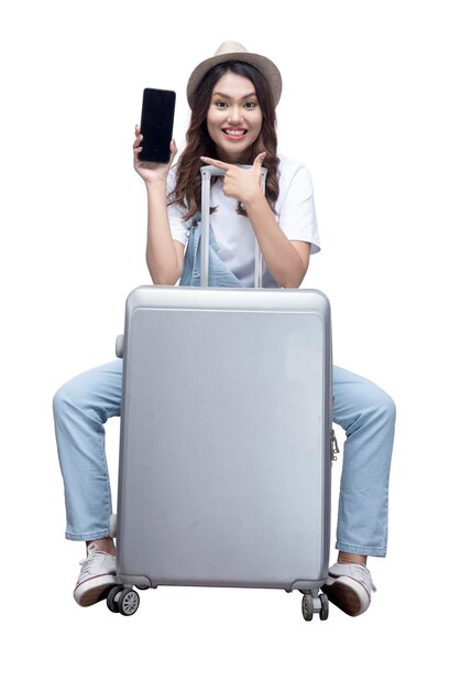 Asian woman with a hat sitting on a suitcase and showing an empty mobile phone screen