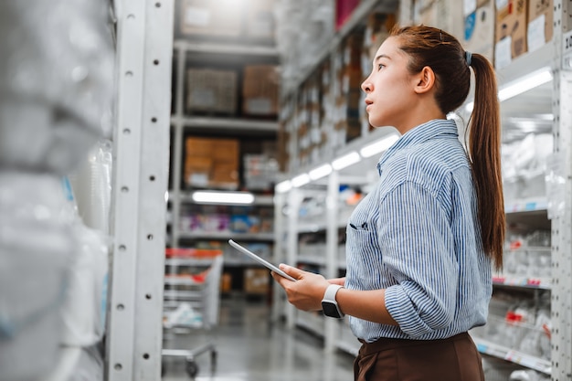 Asian woman worker working with digital tablet checking boxes