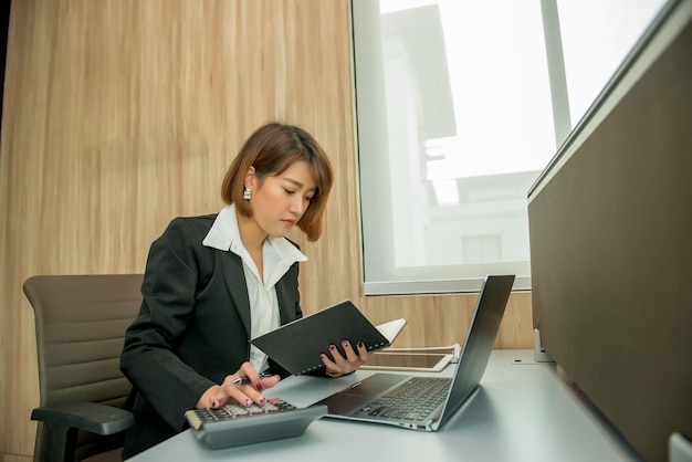 Asian woman working overtime in the office Business a lot of workCheck file with laptopThailand people with office uniform