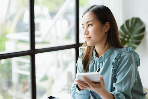 Asian woman working in a startup company she is working in the office run by a young talented woman The management concept runs the company of female leaders to grow the company