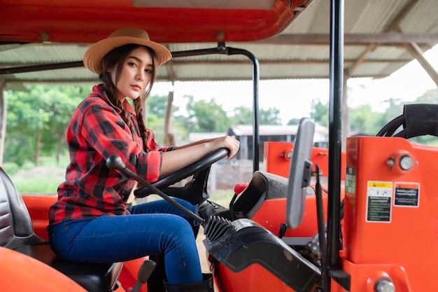 Asian woman working with tractor at cow farmDrive a tractor to plow the fields