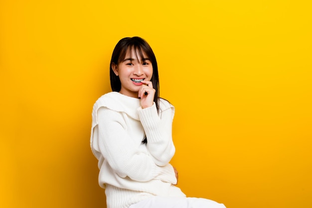 Asian women are cute young cute happy optimistic relaxed good physical health The photo was taken in a yellow backdrop studio