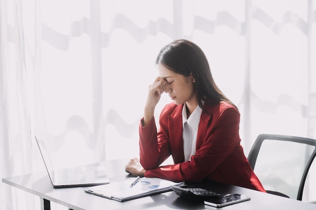 Asian women are stressed while working on laptop Tired asian businesswoman with headache at office feeling sick at work copy space