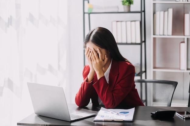 Asian women are stressed while working on laptop Tired asian businesswoman with headache at office feeling sick at work copy space