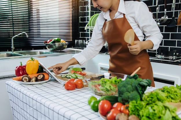 Asian women are using tablets to find recipes from cooking websites at the table