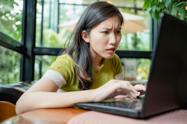 Asian women are using their laptops to work in coffee