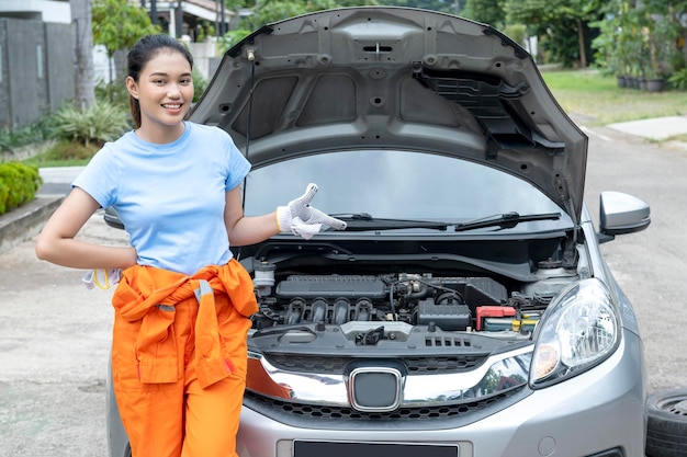 Asian women car technicians in uniform standing while pointing something