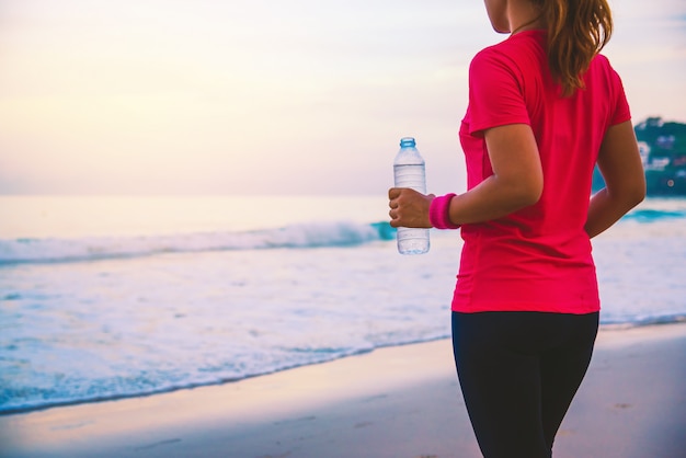 Asian women jogging workout on the beach in the morning. 