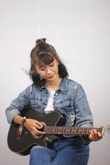 Asian women playing guitar isolated white background