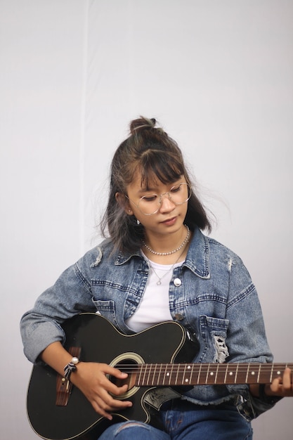 Asian women playing guitar isolated white background