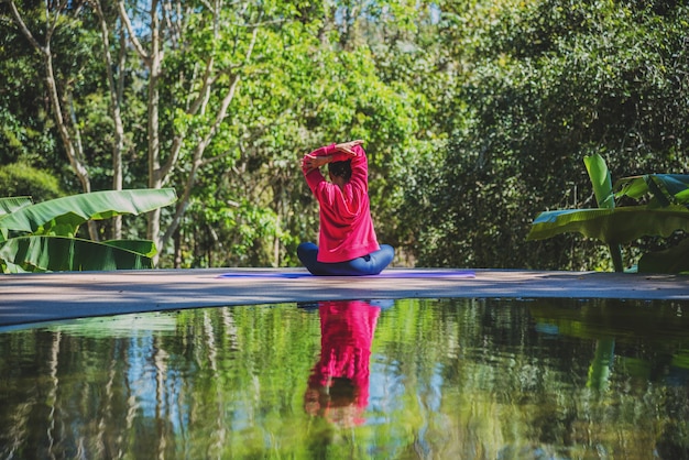 Asian women relax in the holiday. Play if yoga at the pool. Young woman travel nature she standing exercise.