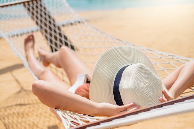 Asian women relaxing in hammock summer holiday on beach