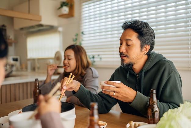 Asian women share a meal with friends at home celebrating the holiday